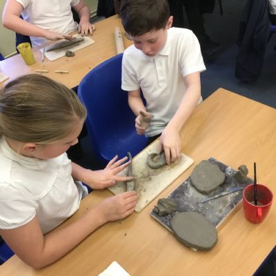 Children making clay lizards